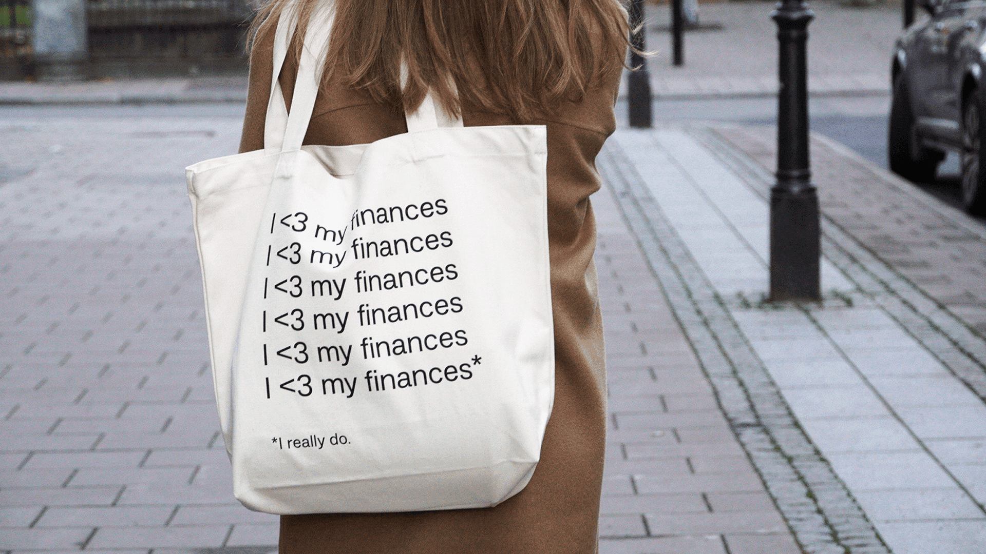 Person som bär en tygkasse med texten I <3 my finances