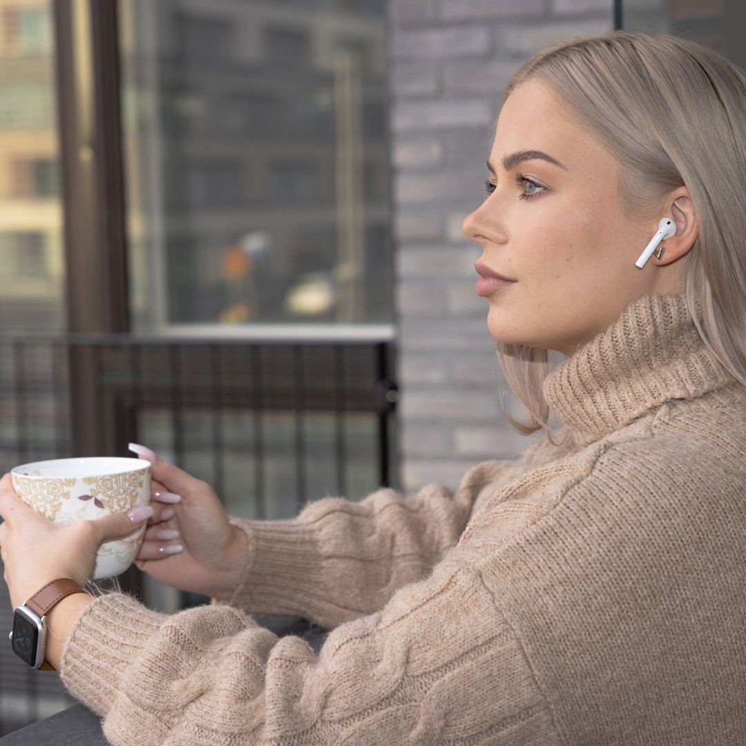 Kundin von Anyfin mit einem Kaffee und Kopfhörern