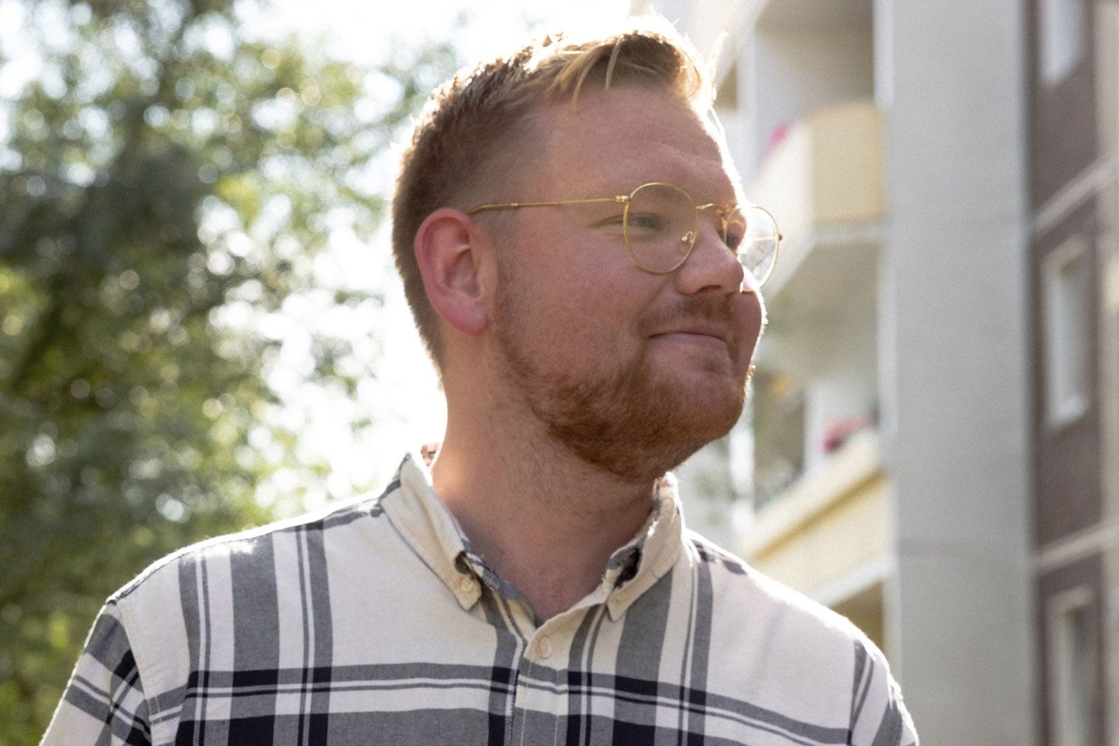 Anyfin-Kunde vor einem Wohnhaus im Sonnenlicht