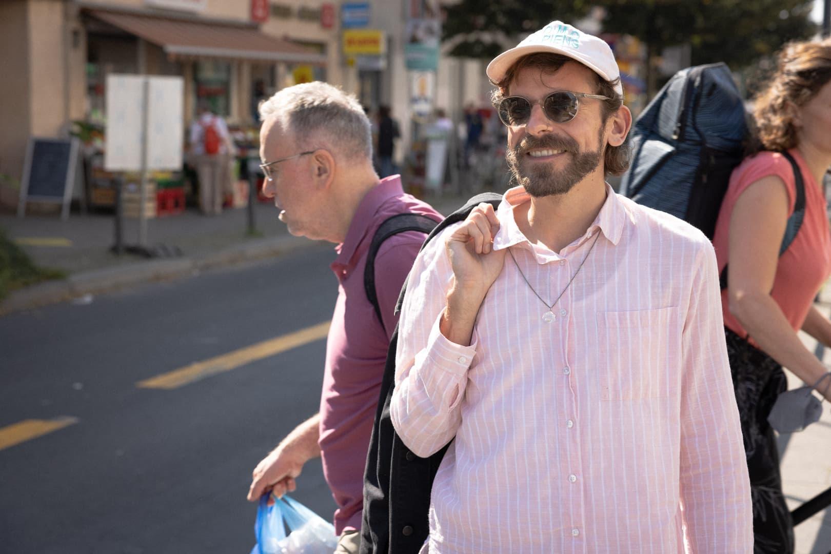 Mann mit Rosa Hemd und rosa Cap in einer Straße