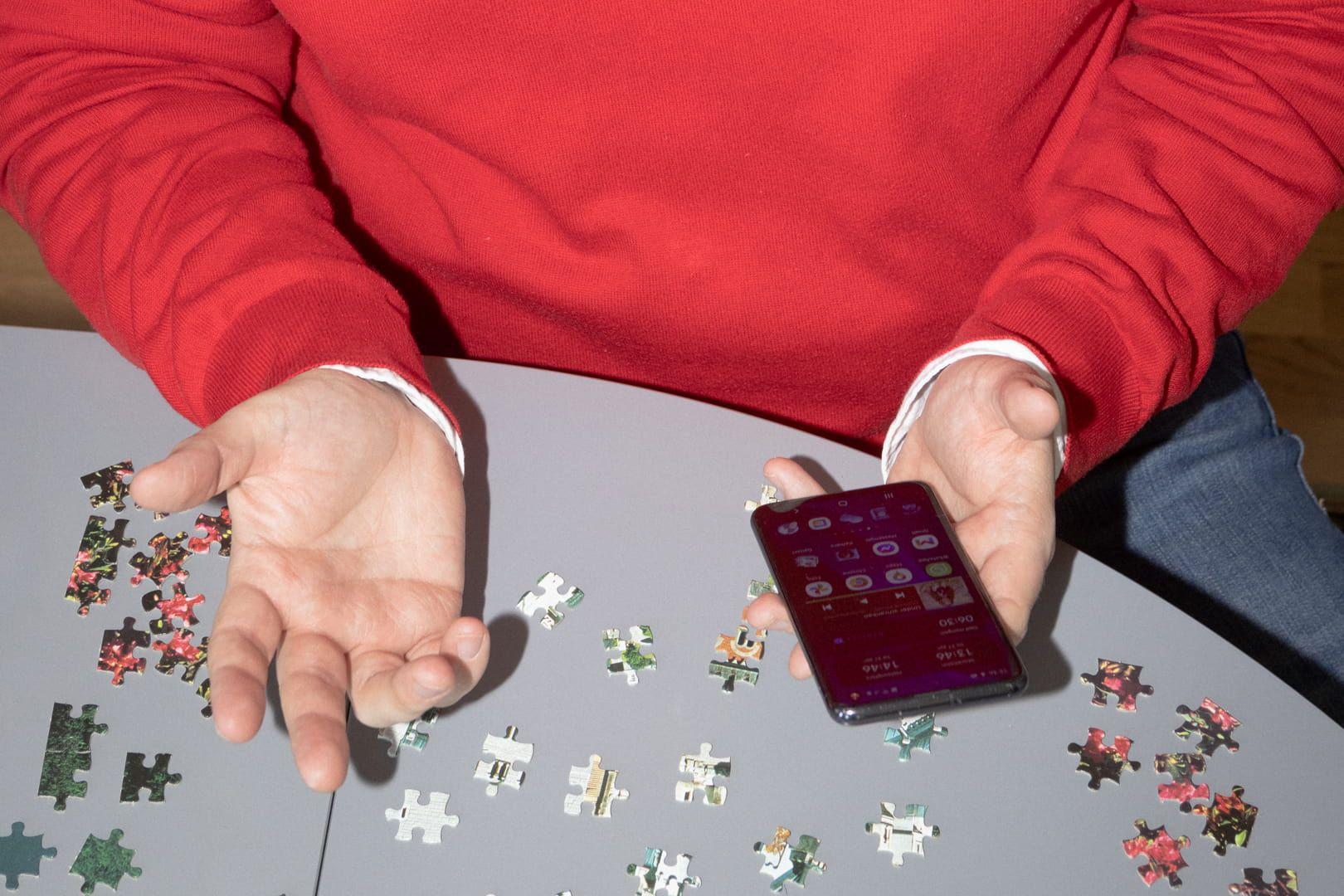 Mensch mit Smartphone und Puzzle